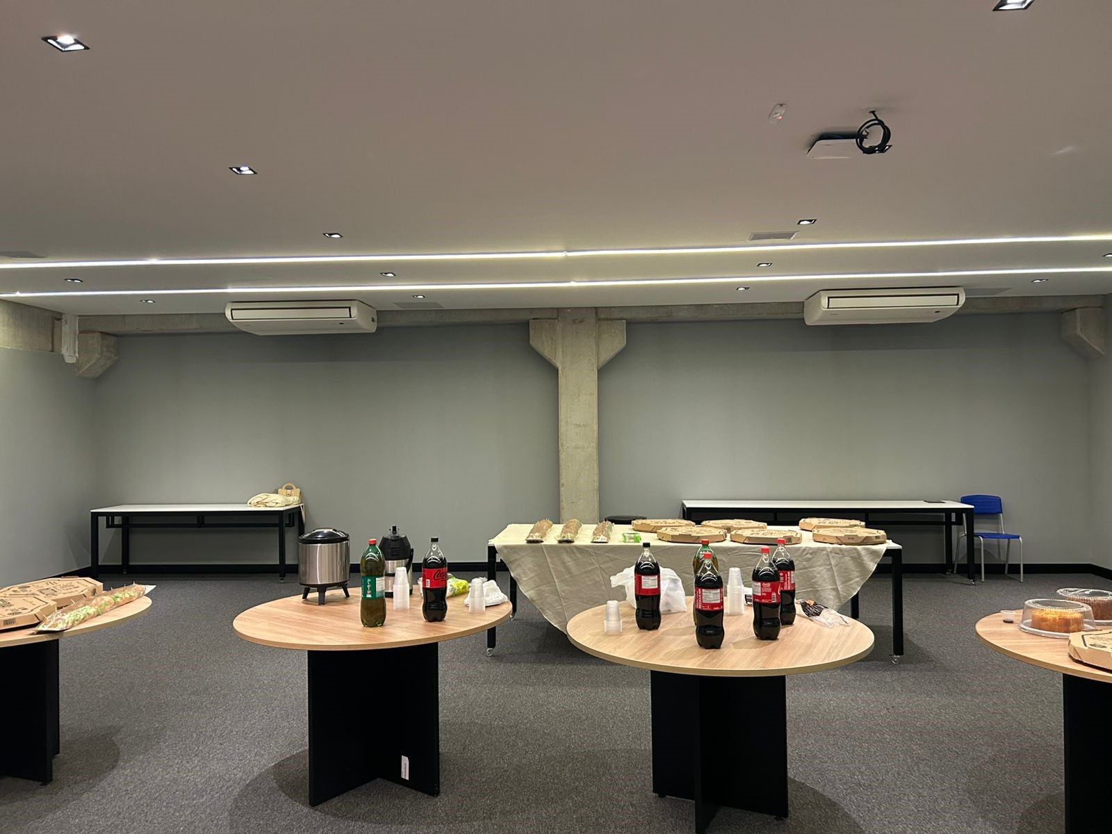 Coffee break preparado com sanduíches, pizzas, refrigerantes e doces no intervalo do evento