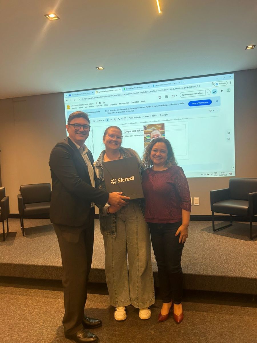 Momento de entrega de brindes ou reconhecimento com representantes da Sicredi no evento